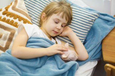 Rahat evindeki yatağında kedisiyle uyuyan bir çocuk. Sevimli, tatlı, küçük bir kızın ev portresi.