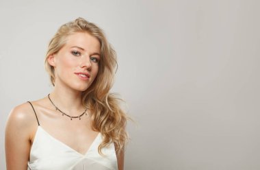 Güzel sarışın model kadın portresi. Güzel bir yüz, sağlıklı bir ten, uzun parlak saçlar ve tatlı bir gülümseme. 