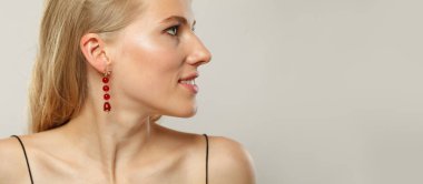 Zarif, genç, sarışın, açık tenli, yumuşak makyajlı, sağlıklı saçlı ve doğal duygusal ifade portresi olan bir manken. Beyaz arka planda sarışın kadın.