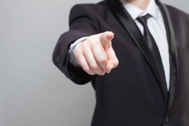 Siyah takım elbiseli iş adamı kameraya bakıyor..