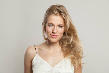 Kameraya bakan sevimli gülüşü olan tatlı sarışın kadın. Güzel genç yetişkin portresi.