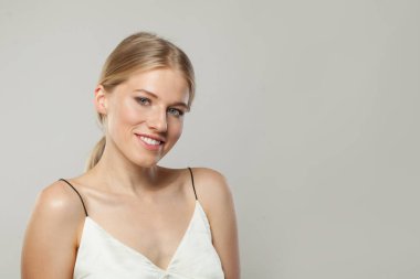 Neşeli gülümseyen kadın. Sarışın ve temiz ciltli kadın modeli, yüz bakımı, cilt bakımı ve güzellik konsepti.