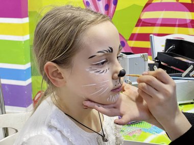 Yaratıcı karnaval makyajı için bekleyen kız çocuğu