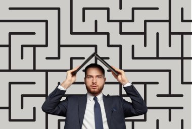 İş adamı, arka planda Labirynth vektörüyle dizüstü bilgisayarının altında saklanarak stres içinde çalışıyor. Bunaltıcı, çözüm bulma kavramı