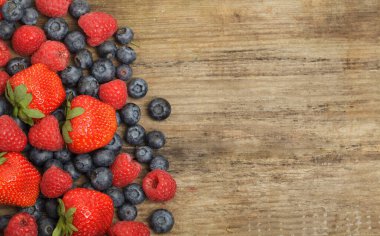 Kırmızı çilek, ahududu ve yabanmersinli organik meyve arkaplanı