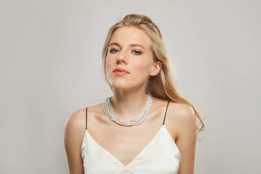 Sarışın model kadın portresi. Güzel bir yüz, sağlıklı bir cilt, uzun parlak saçlar ve inci kolye.