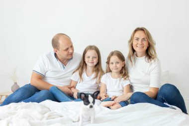 Sevgili anne babaları ve kızları kapalı bir yatakta eğleniyorlar.