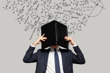 Gergin iş adamı, arka planda matematiksel formüllerle başını dizüstü bilgisayarın altına gizliyor. Para, eğitim ve girişimcilik kavramı