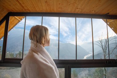 Gürcistan, Variaki 'deki dağlara bakan beyaz bornozlu güzel sarışın kadın.