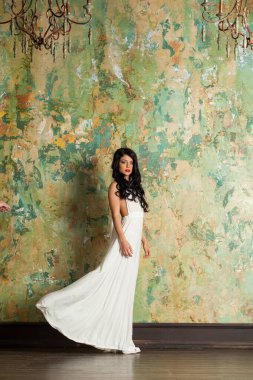 Güzel genç bayan model esmer. Kapalı alanda kameraya bakıyor. Tam boy portre.