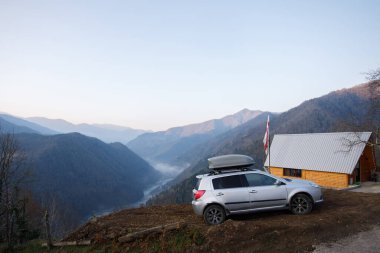 Dağların muhteşem manzarası, gri araba ve Georgia Variaki 'deki ev.