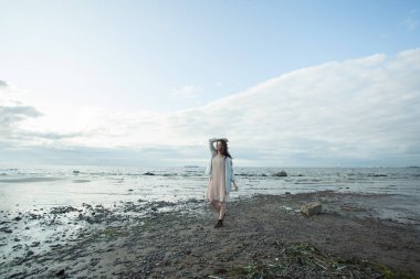 Açık havada dinlenen esmer bir kadının tam boy portresi.