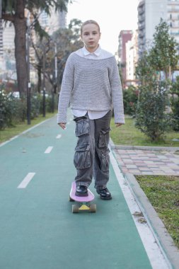 Dışarıda kaykayla gezen güzel bir kız çocuğu.