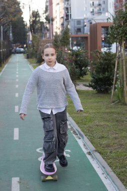 Pembe kaykaylı şirin bir kız çocuğu. Kaykay yetenekleri.