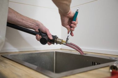 Mutfaktaki musluğu tamir et, su sızdıran tamircinin ellerini kapat.