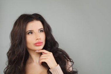 Model kadın gri arka planda poz veriyor. Moda portresi.