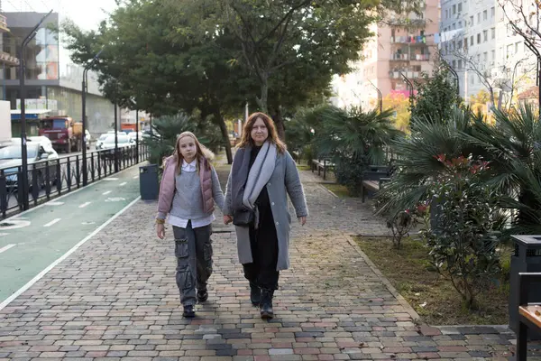 Sonbahar yürüyüşü. Kız ve anne dışarıda yürüyor.