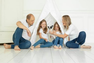 Evde evcil köpek yavrusuyla eğlenen bir aile..