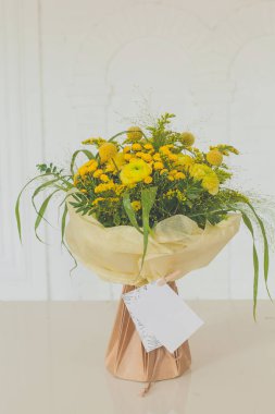 Güzel doğum günü hediyesi. Beyaz arka planda, el işi kağıt torbada çiçek buketi..