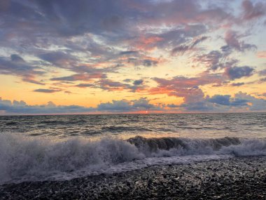 Deniz üzerinde dramatik bulutlarla akşam gökyüzü. Denizin üzerinde dramatik gün batımı.