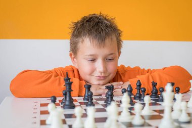 Sınıfta satranç oynayan yakışıklı bir öğrenci. Evde satranç oynayan çocuk