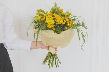 Yellow flower in hand on white background