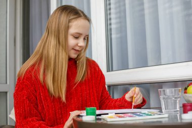 Parlak renklerle mutlu çocuk resimleri. Evde genç bir kız, hobi ve eğlence.