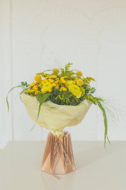 Çiçek Doğum günü Hediyesi. Beyaz arka planda, el işi kağıt torbada çiçek buketi.