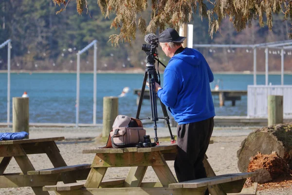 Profesyonel Bir Fotoğrafçının Manzaralı Bir Göl Manzarası Için Kamerasını Ayarlarken — Stok fotoğraf