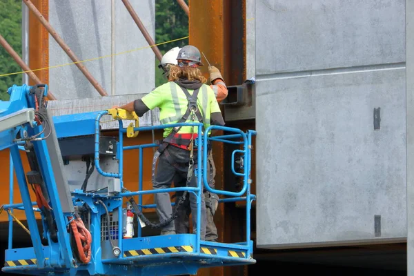 工业用建筑用升降机将两名建筑工人安置在建筑物侧边的全景 — 图库照片