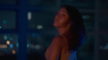 Gece Şehrine Karşı Genç Bir Cazibeli Kadın Portresi. Kameraya gülümsüyor. El bilgisayarı Bokeh Orta Çekim