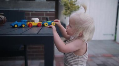 Masanın üzerinde duran oyuncağıyla oynayan bir çocuğun orta boy fotoğrafı.