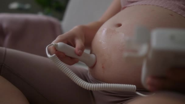 胎児のハートビートを検出するためにドプトンを使用している間 妊婦の腹のクローズアップショット — ストック動画