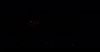 Bir havai fişek videosu ışık efektleri alanını patlatarak ve genişleterek gece gökyüzünü yavaşça aydınlatıyor.