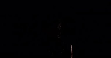Havai fişekleri yukarı doğru hareket ederken gösteren bir video. Sonra gökyüzünü kızılımsı pembe bir renkle aydınlatıyor.