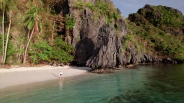 Güneşli bir günde Entalula Sahili 'nde tek başına gezen bir kadın.