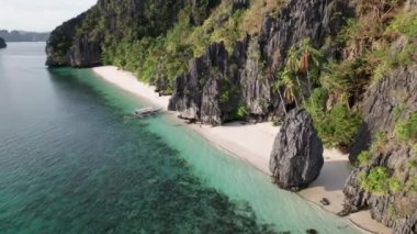 Entalula Sahili kıyısındaki rıhtımlı bir tekneden çok yavaş çekimde uzaklaşan bir kadın.