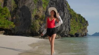 Entalula Sahili 'nin kayalık manzarasına hayran güzel bir kadın.