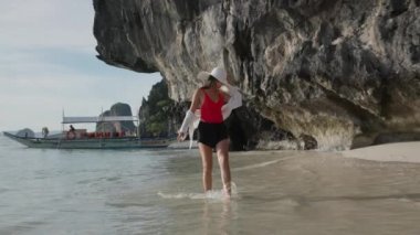 Genç kadın kaygısız ve kumsalda güneşli bir gün yaşıyor.