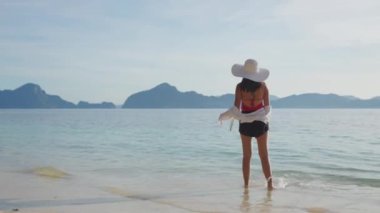 Manzaranın tadını çıkaran ve Entalula Sahili 'nin önündeki adalara bakan bir kadının geniş açılı görüntüsü..