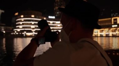Dubai çeşme gölünde hareket halindeki bir feribotta Burj Halife 'nin resimlerini çeken birinin yakın çekimi.