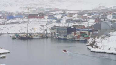 Ilulissat 'ta karlı bir günde geniş açılı bir liman ve kasaba manzarası