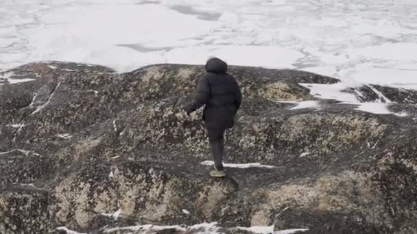 Seorang Pria Perlahan Lahan Mendaki Gunung Kasar Pada Hari Bersalju — Stok Video
