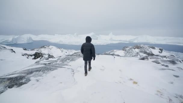 イルリサットの雪の山の頂上に到達した男のワイドショット — ストック動画