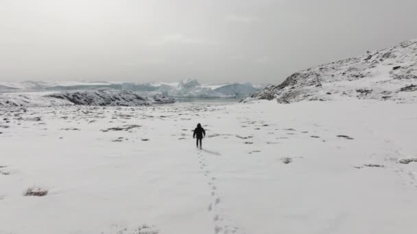 Zdjęcie Lotnicze Mężczyzny Patrzącego Długą Śnieżną Ścieżkę Ilulissat — Wideo stockowe