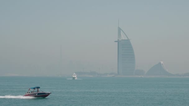 一艘快艇在海上穿行 雾蒙蒙地看到了Burj Arab — 图库视频影像