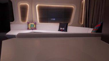 V Hotel Dubai 'de merkezinde yuvarlak bir masa bulunan eğimli bir otel oturma alanı..