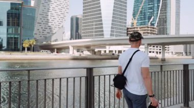 JW Marriott Marquis Hotel Dubai 'de, nehir boyunca yürüyen bir fotoğrafçının yavaş çekim görüntüsü..