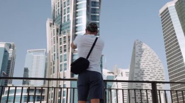 Dubai 'de lüks bir gökdelen oteli olan JW Marriott Marquis' in videosunu çeken bir adamın düşük açılı görüntüsü..