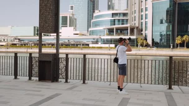 图为一名男子在迪拜Al Manara塔附近的河对岸拍摄高楼和摩天大楼的照片 — 图库视频影像